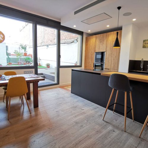 Cocina-comedor después de la reforma integral en Eixample Dret, Barcelona con vistas al patio.