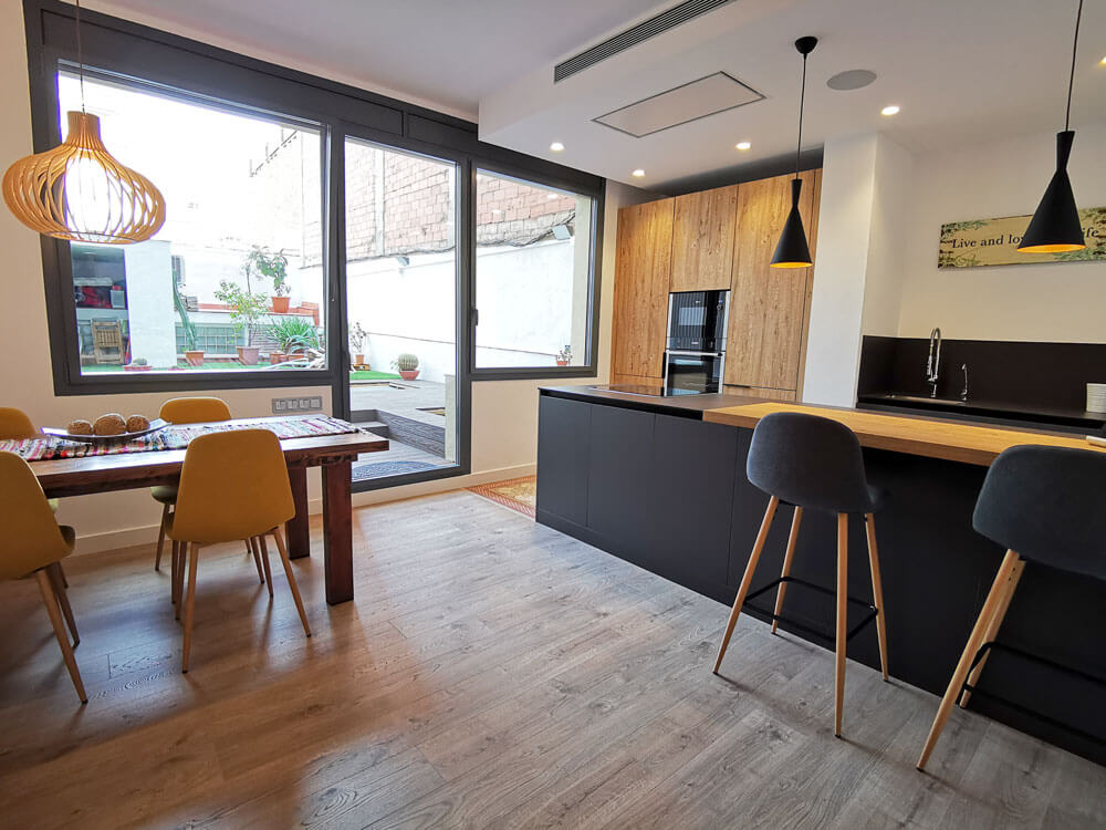 Cocina-comedor después de la reforma integral en Eixample Dret, Barcelona con vistas al patio.